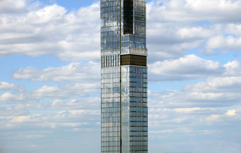Fotografia da fachada de vidro do edifício residencial mais alto do mundo, com padrões modulares que estruturam a torre.
