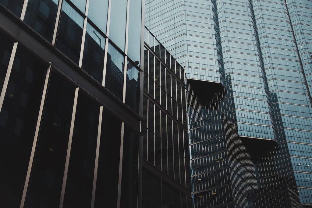 Fotografia de edifícios com fachada de vidro espelhada.