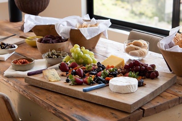 Mesa servida com frutas, queijos e pequenos petiscos. Ótima pedida para o open house.
