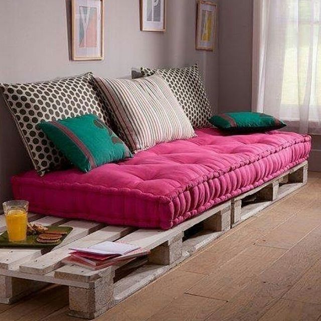 Os paletes usados como base para o sofá colorido de três lugares.