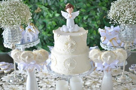 Mesa do bolo, toda branca, com um anjinho de topo de bolo.