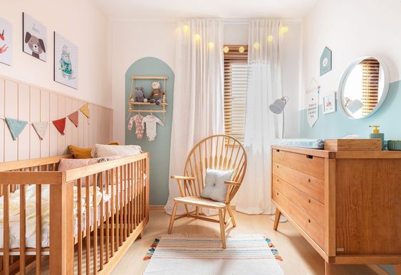 Quarto de bebê com mistura de cores com tons claros e mobiliários em madeira, proporcionando uma visão de conforto.