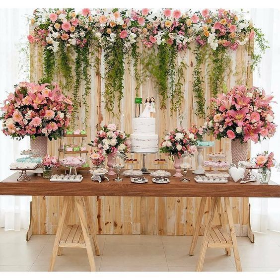 Decoração para casamento, com bolo naked cake, flores e elementos decorativos que remetem ao estilo. 
