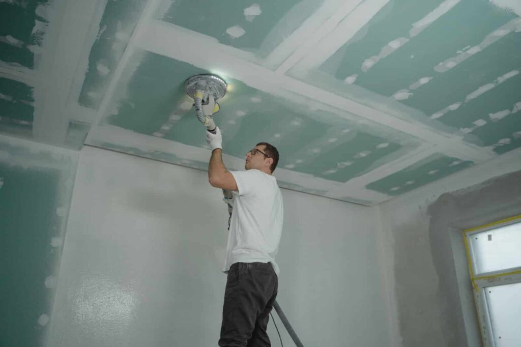 Trabalhador fazendo detalhes da pintura de parede, uma mão de obra especializada oferecida pela personalização.