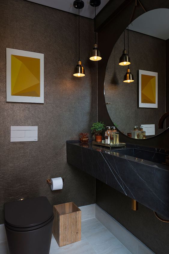 Ambiente decorado com um quadro na parede que fica atrás do vaso sanitário.