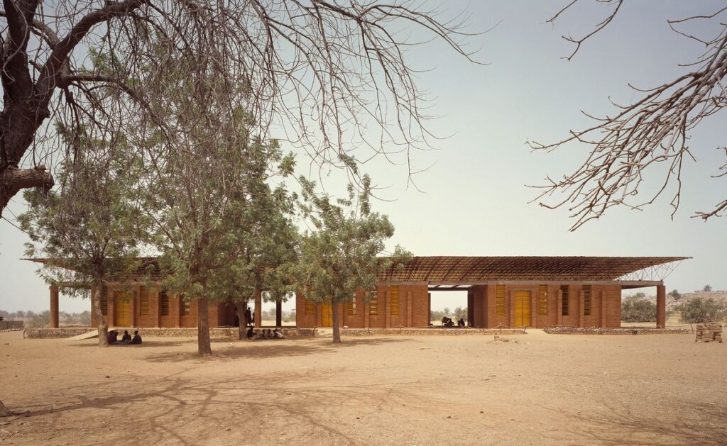 Fotografia da escola, com um formato retangular e horizontal, recostado por dois pátios.