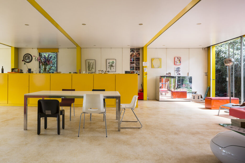 Parte interna da Casa Rogers, onde a cor amarela predomina na cor dos móveis e nas vigas e pilares.