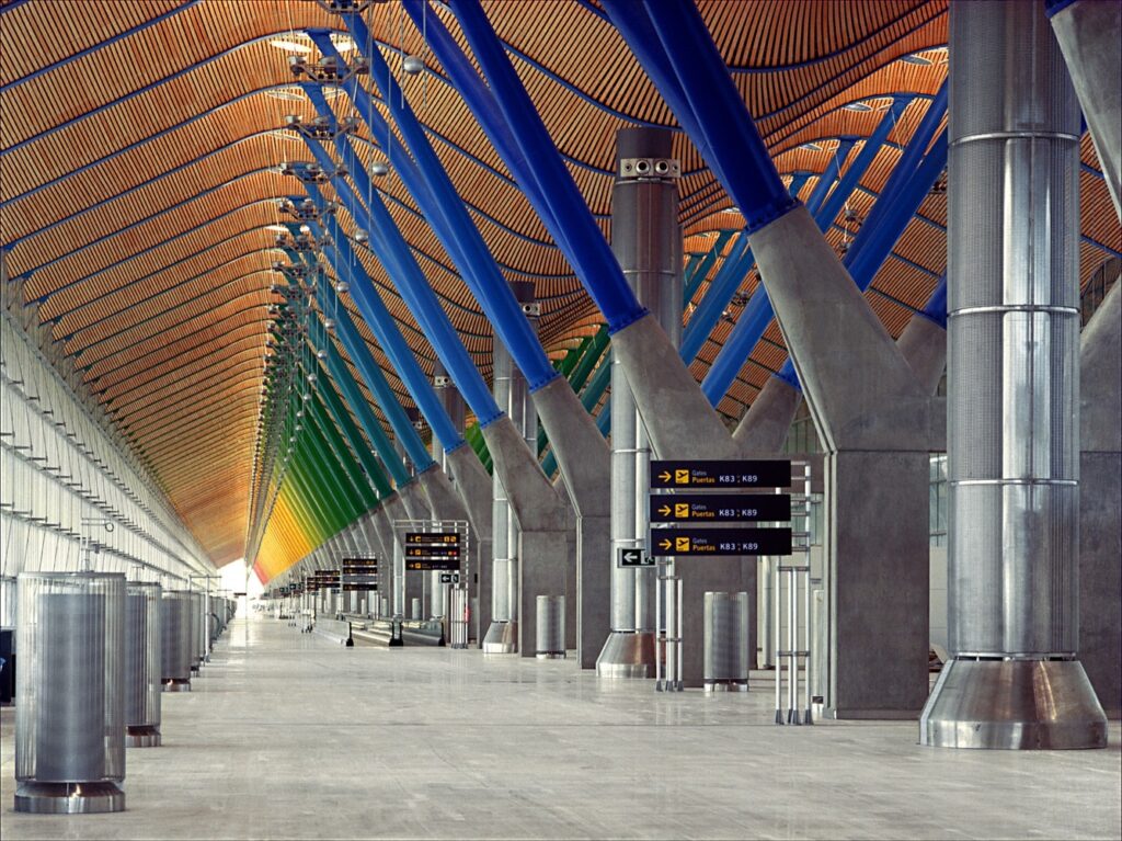 Imagem da parte interna do Terminal do Aeroporto de Madri-Barajas, com seus pilares coloridos. 