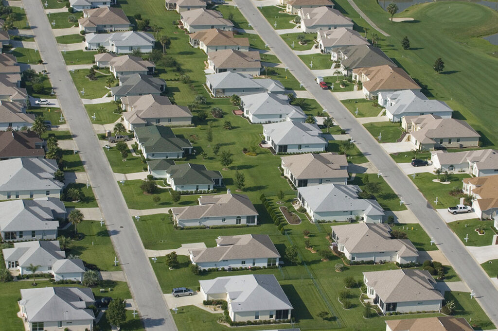 Fotografia aérea residencial com amplas casas de 2 pavimentos padronizadas.