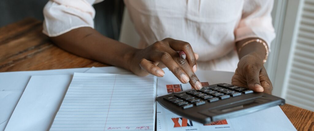 Mulher calculando como declarar imposto de renda de imóveis financiado.