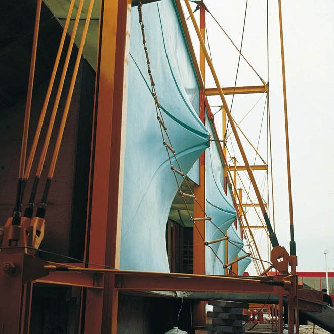 Fotografia da estrutura do Pavilhão, com vigas e pilares metálicos, além de cabos tracionados.