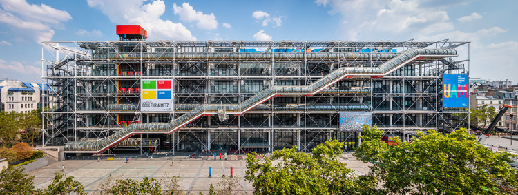 Fotografia da fachada principal do Centro Pompidou, com estrutura predominantemente metálica e escada rolante externa.