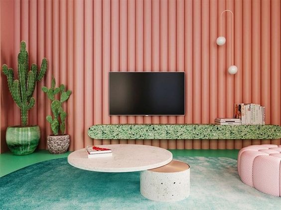 Sala de televisão decorada com tonalidades de rosa e verde.
