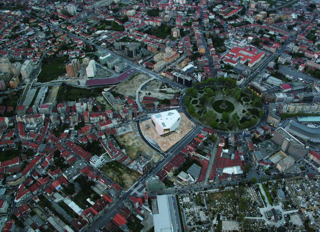 Vista aérea da Casa da Música em meio a cidade de Porto.