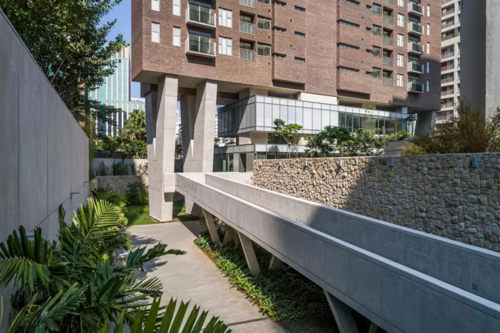 Os pilares em Y do Casa Brasileira Itaim e a elegante passarela de concreto aparente que dá acesso ao hall social. 